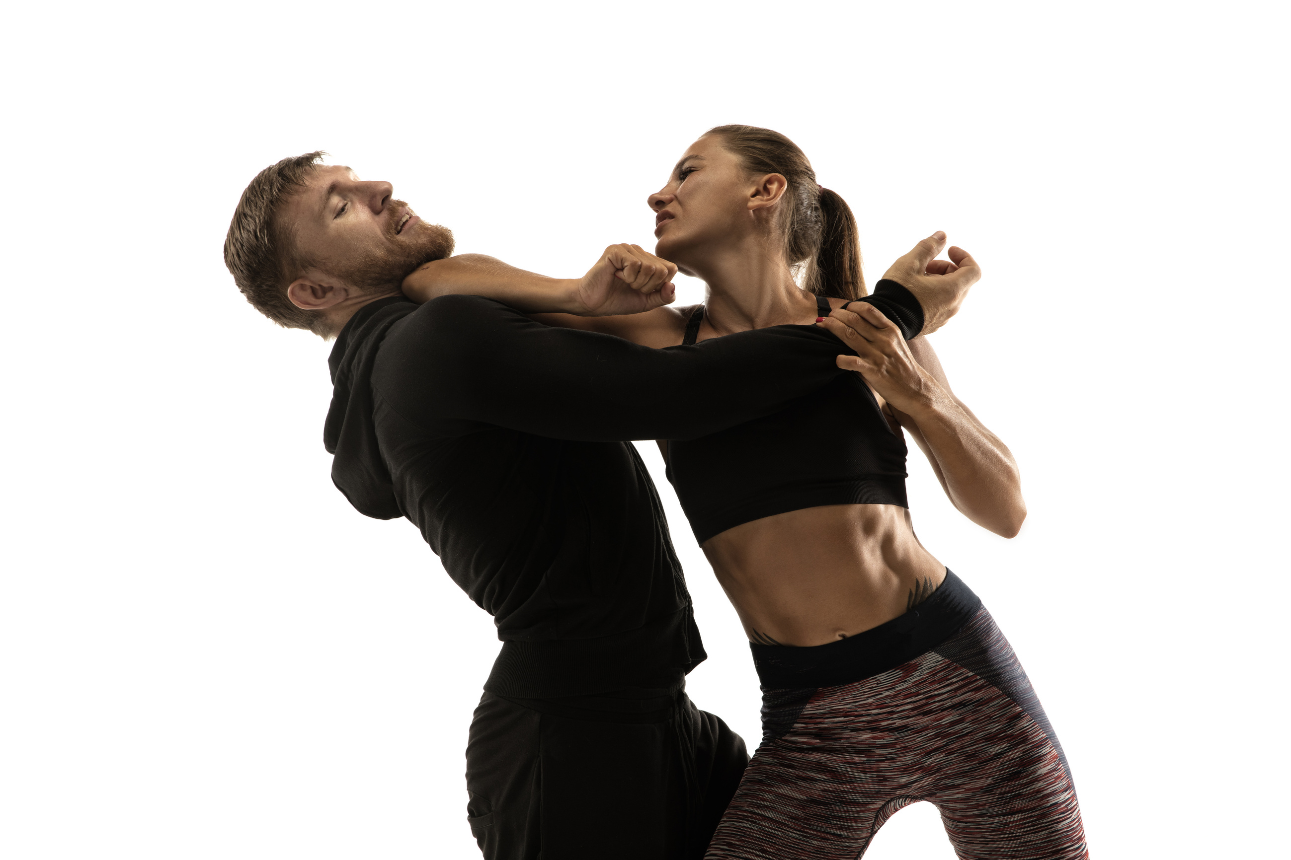Man and woman fighting in studio, women's self-defense concept
